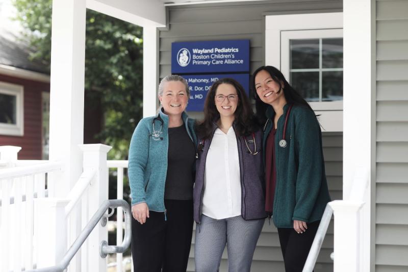 three women staying on the porch of a house